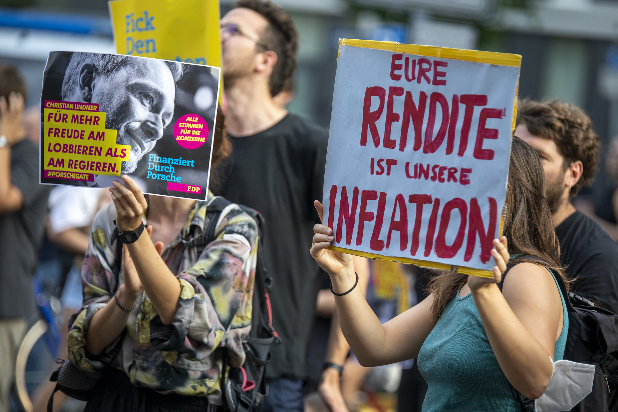 Proteste vor FDP Parteizentrale. Eine junge Frau hält ein Plakat "Eure Rendite ist unsere Inflation" hoch.