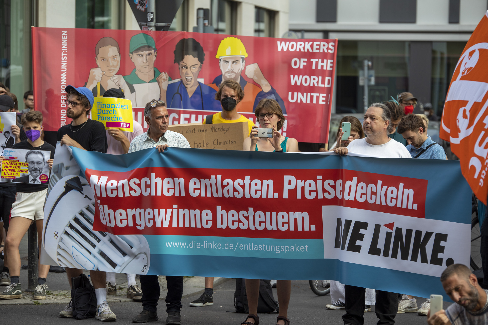 Foto von Protest vor FDP. Menschen halten ein Banner auf dem steht "Menschen entlasten. Preise deckeln. Übergewinne besteuern. DIE LINKE"Parteizentrale.
